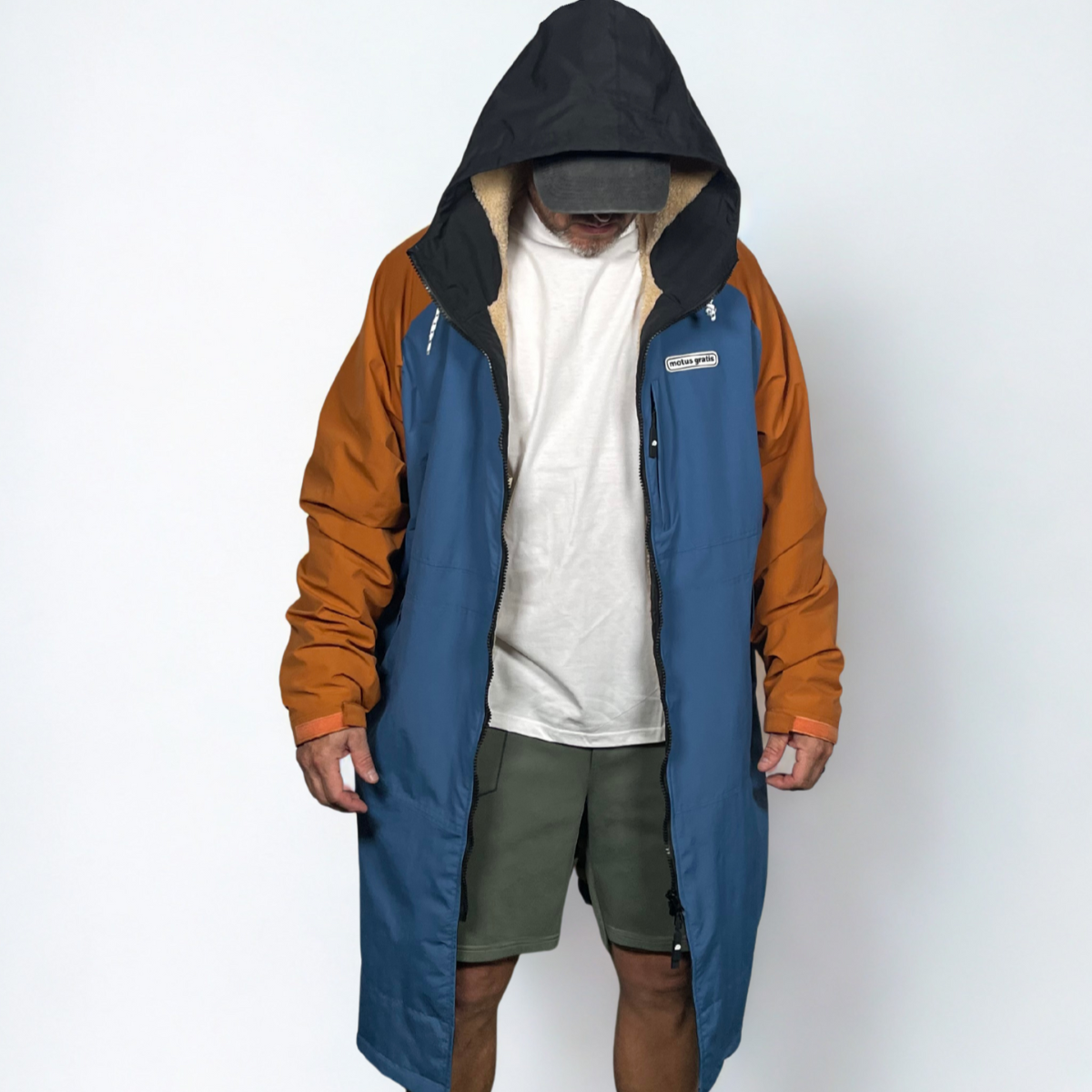 Person wearing a two-tone jacket with blue and brown sections on a white background